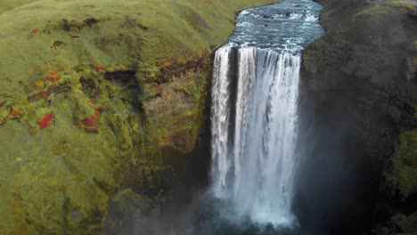 Roaring-Skogafoss-waterfall-water-spray-in-verdant-canyon,-Iceland