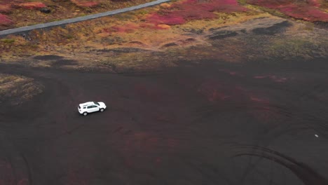 Weißes-SUV-Auto-Fährt-Am-Vulkanischen-Schwarzen-Sandstrand-Im-Nordischen-Island