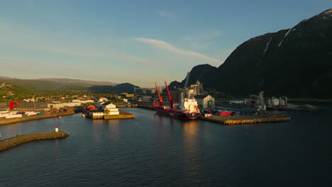 Container-ship-with-cranes-at-dock-of-Mosjøen-aluminium-plant,-Norway