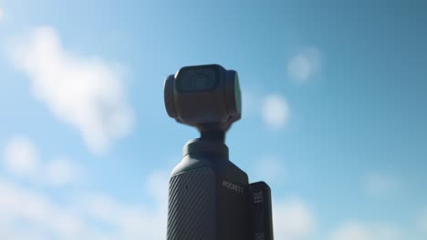 Close-Up-Shot-Of-DJI-Osmo-Pocket-3-Against-Sunny-Blue-Skies