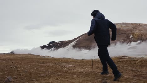El-Hombre-Corre-Sobre-Terreno-De-Grava-Naranja-En-El-área-Geotérmica-De-Myvatn,-Islandia