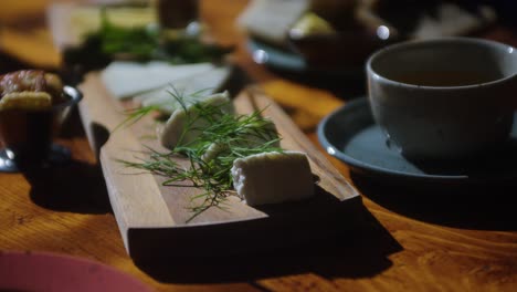 Close-up-shot-of-cheese-selection-board-on-table-at-bright-restaurant