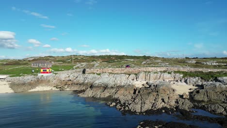 Drone-shot-starts-on-person-standing-on-the-shore-at-Coral-Beach-in-Ballyconneely,-then-reveals-the-ocean,-aerial-footage