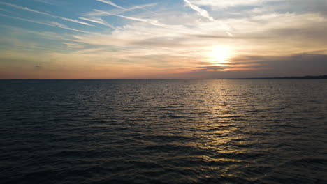 Der-Rückzug-Der-Drohne-Zieht-Sich-Nach-Sonnenuntergang-über-Atemberaubendem,-Klarem-Meereswasser-Zurück