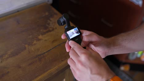 Over-The-Shoulder-View-Of-Content-Creator-Using-DJI-Osmo-Pocket-3-In-Caf?