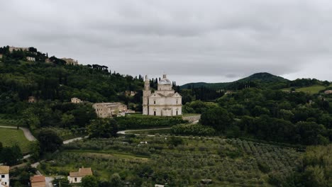 Drone-shot-of-Italy's-countryside-with-a-few-sandstone-buildings-throughout-the-landscape