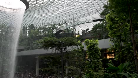 Der-Regenwirbel-Indoor-Wasserfall-Am-Jewel-Changi-Airport-Singapur-Mit-Vorbeifahrendem-Skytrain