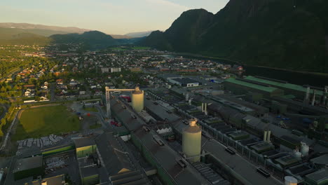 Antena-Bajo-El-Sol-De-Medianoche-Sobre-La-Planta-De-Fabricación-De-Aluminio-De-Mosjøen,-Vefsn,-Noruega