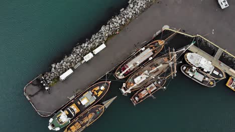 Top-down-aerial-of-of-boats-in-the-harbour-of-Seyðisfjörður,-a-small-town-in-Iceland