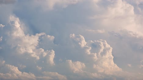 Time-lapse,-cloudscape-view-of-white-fluffy-clouds-moving-in-the-wind-over-a-blue-sky