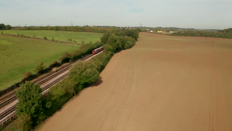 Rising-aerial-shot-of-London-underground-train-heading-towards-Epping-town
