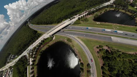 Aerial-drone-push-out-bridge-cars-passing-by-on-highway-spinning-into-a-fish-eye-lens-view