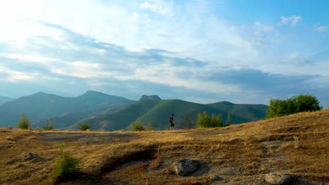 single-man-hiking-outdoors-on-epic-mountains-landscape,-tracking-shot