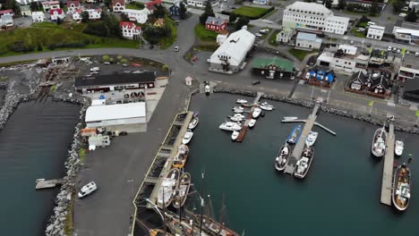 Antena-De-Barcos-En-El-Puerto-De-Húsavík,-Un-Pequeño-Pueblo-En-Islandia