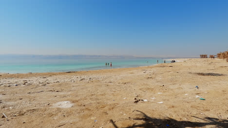 Wide-angle-view-from-tropical-cabana-of-people-playing-and-walking-in-the-dead-sea