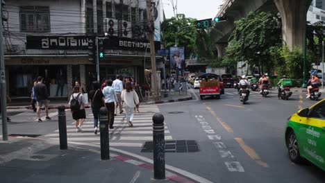 Green-light-turns-on-people-can-cross-the-Pedestrian-Lane-while-vehicles-also-move-forward,-Sukhumvit-26-across-is-Beethoven-tailoring,-Bangkok,-Thailand