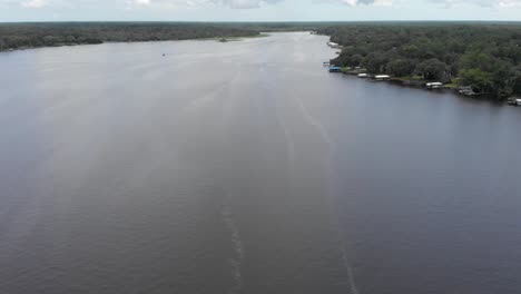 Luftaufnahme-Mit-Blick-Auf-Das-Wasser,-Yachthafen,-Schnellboot,-Das-Im-Wasser-Vorbeifährt,-Segelboot,-Fischer,-Grünflächen-Und-Bäume-Im-Hintergrund