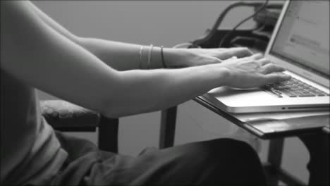 Schwarz-Weiß-Video-Einer-Frau,-Die-Während-Ihrer-Arbeit-Auf-Einer-Laptop-Tastatur-Tippt