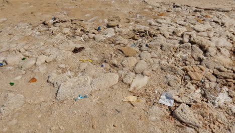 Dirt-and-litter-trash-from-partying-tourists-strewn-across-rocks-of-the-Dead-Sea
