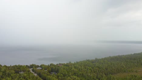 Foggy-rainclouds-flowing-over-forest-in-Bruce-peninsula,-aerial-view