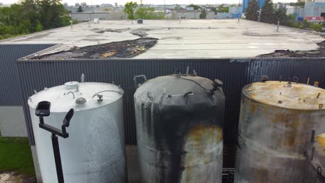 Aerial-view-over-burnt-industrial-containers,-extinguished-fire-of-hazardous-materials