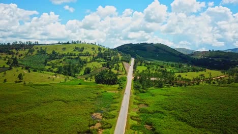 Country-Road-Between-Green-Fields-In-Uganda,-East-Africa---aerial-drone-shot