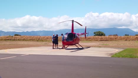 Gimbal-wide-dolly-shot-from-a-moving-vehicle-driving-past-various-helicopters-lined-up-on-the-tarmac-at-a-heliport-on-the-island-of-Kaua'i-in-Hawai'i