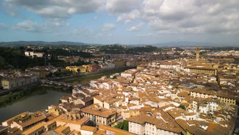 Sonnenlicht-Strömt-Auf-Die-Antike-Stadt-Florenz,-Italien,-Mit-Wolkenschatten-über-Kanal-Und-Berg