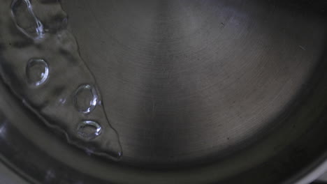 Kochendes-Wasser,-Das-In-Einer-Stahlpfanne-Vorsichtig-Hin-Und-Her-Bewegt-Wird
