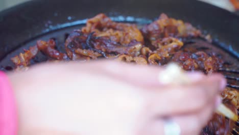 Close-up-shot-hand-of-people-cooking-Barbeque meat-using-chopsticks-on-the-grill-pan
