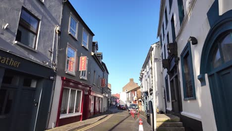 Walking-on-a-sunny-day-on-the-street-of-Kinsale-with-restaurants-and-cafes,-small-shops