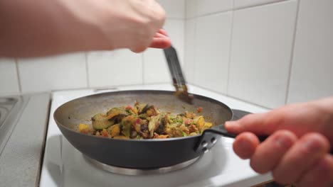 Man-mixing-up-vegetables-in-a-frying-pan