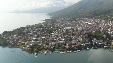 Drone-push-in-above-beatiful-coastline-community-by-Lake-Atitlan-Guatemala