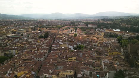 Drone-Asciende-Muy-Por-Encima-De-Florencia-Italia-Extensos-Edificios-De-La-Ciudad-Hasta-Las-Montañas