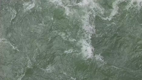 Grünliches-Wasser,-Das-In-Einem-Tief-Fließenden-Fluss-Herumwirbelt