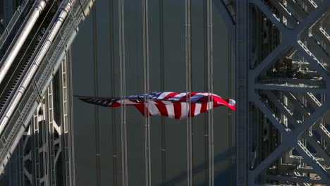 Eine-Luftaufnahme-Des-Turms-Auf-Der-New-Jersey-Seite-Der-George-Washington-Brücke-Mit-Einer-Riesigen-Amerikanischen-Flagge,-Die-An-Einem-Sonnigen-Tag-Weht