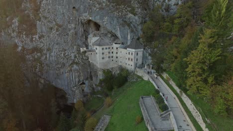 aerial-slow-motion-shot-with-forward-move-out-on-Predjama-Castle-at-sunset