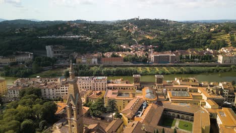 Drone-flyover-rear-tower-of-Basilica-of-Santa-Croce-in-Florence-Italy-to-canal-of-the-city