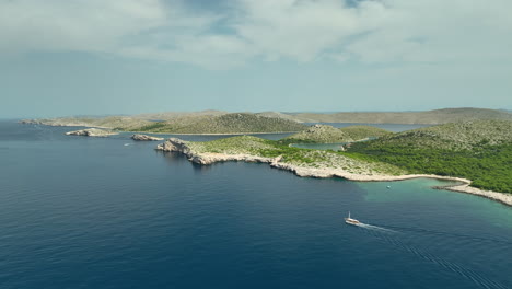 Trucking-drone-shot-of-yacht-sailing-next-to-the-island-in-Kornati-national-park