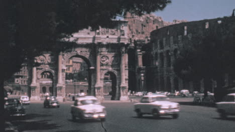 Tráfico-En-La-Calle-Con-El-Arco-Triunfal-De-Constantino-En-El-Fondo-En-Roma-1960
