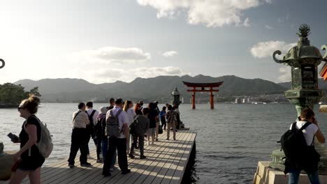 Touristen-Stehen-Schlange,-Um-Ein-Foto-Des-Im-Wasser-Schwimmenden-Itsukushima-Jinja-Otorii-Zu-Machen