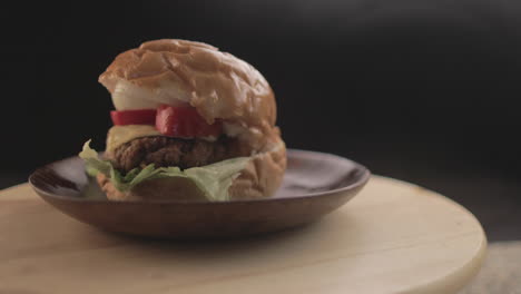 Rindfleisch--Oder-Hühnerburger,-Köstliches-Burger-Sandwich,-Mit-Schwarzem-Hintergrund-Und-Einfachem-Lichtaufbau,-Aufgenommen-Auf-Rohem-4k