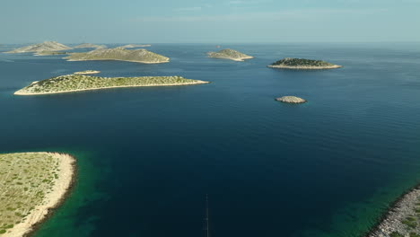 Aerial-backwards-drone-panning-shot-of-a-yacht-anchored-between-islands