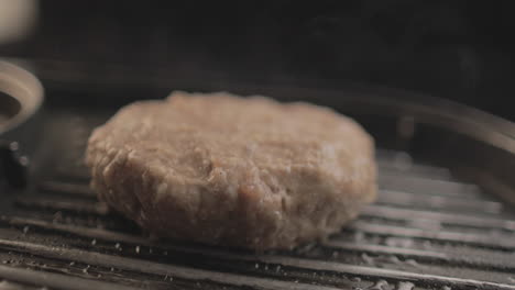 Beef-or-Chicken-Burger-on-grill-being-prepared-for-a-delicious-burger-sandiwich-,-with-a-black-background-and-simple-light-set-up-shot-on-RAW-4K