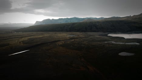 Luftaufnahme-Von-Island,-Moosige,-Grasige,-Felsige-Landschaft,-Blick-Auf-Die-Isländischen-Vulkanberge-In-Der-Ferne