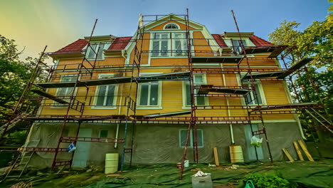 Time-lapse-of-people-on-scaffold-painting-house-day-to-night-transition
