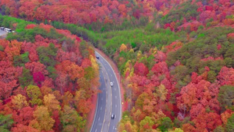 Landscapes-of-Dalton,-Georgia,-aerial-perspective-gracefully-captures-the-beauty-of-autumn-as-it-blankets-the-highway-traffic-with-vibrant-hues
