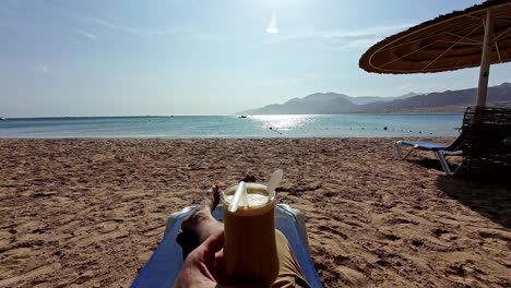 Sentado-En-Una-Playa-Del-Mar-Rojo-Disfrutando-De-Un-Cóctel