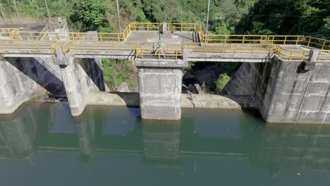 Aerial-tilt-down-shot-of-Tireo-Dam-construction-building-with-green-water-in-Bonao