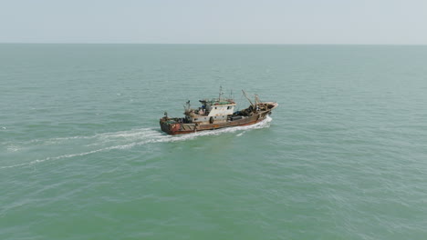 Schnelle-Luftaufnahmen,-Die-Einem-Fischkutter-Folgen,-Der-Vor-Der-Küste-Gambias-Unterwegs-Ist